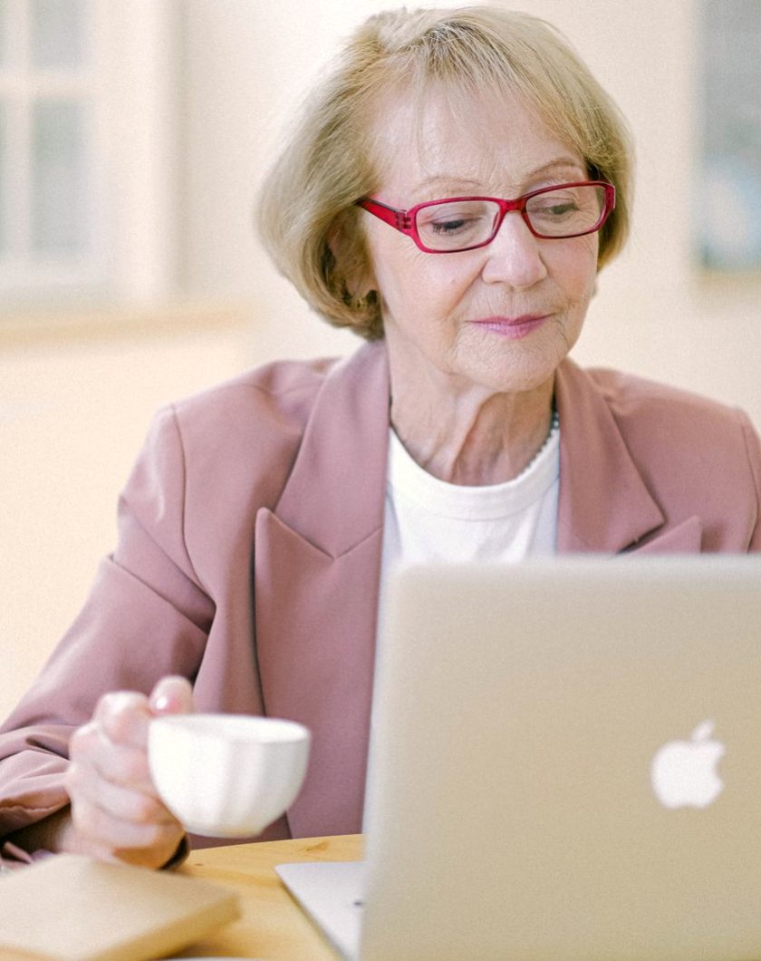 Une lectrice parcourt un site culturel sur son ordinateur portable, à la maison